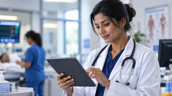 A clinician reviewing information on a tablet in a clinical setting.